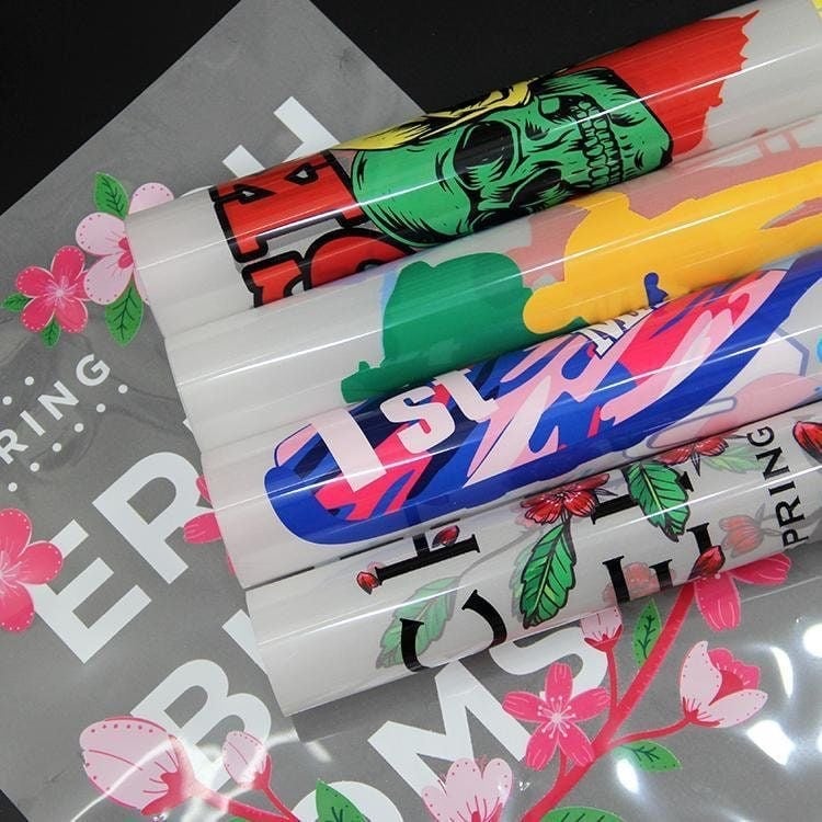 Stack of colorful printed apparel with vibrant full-color graphics and pink floral detail